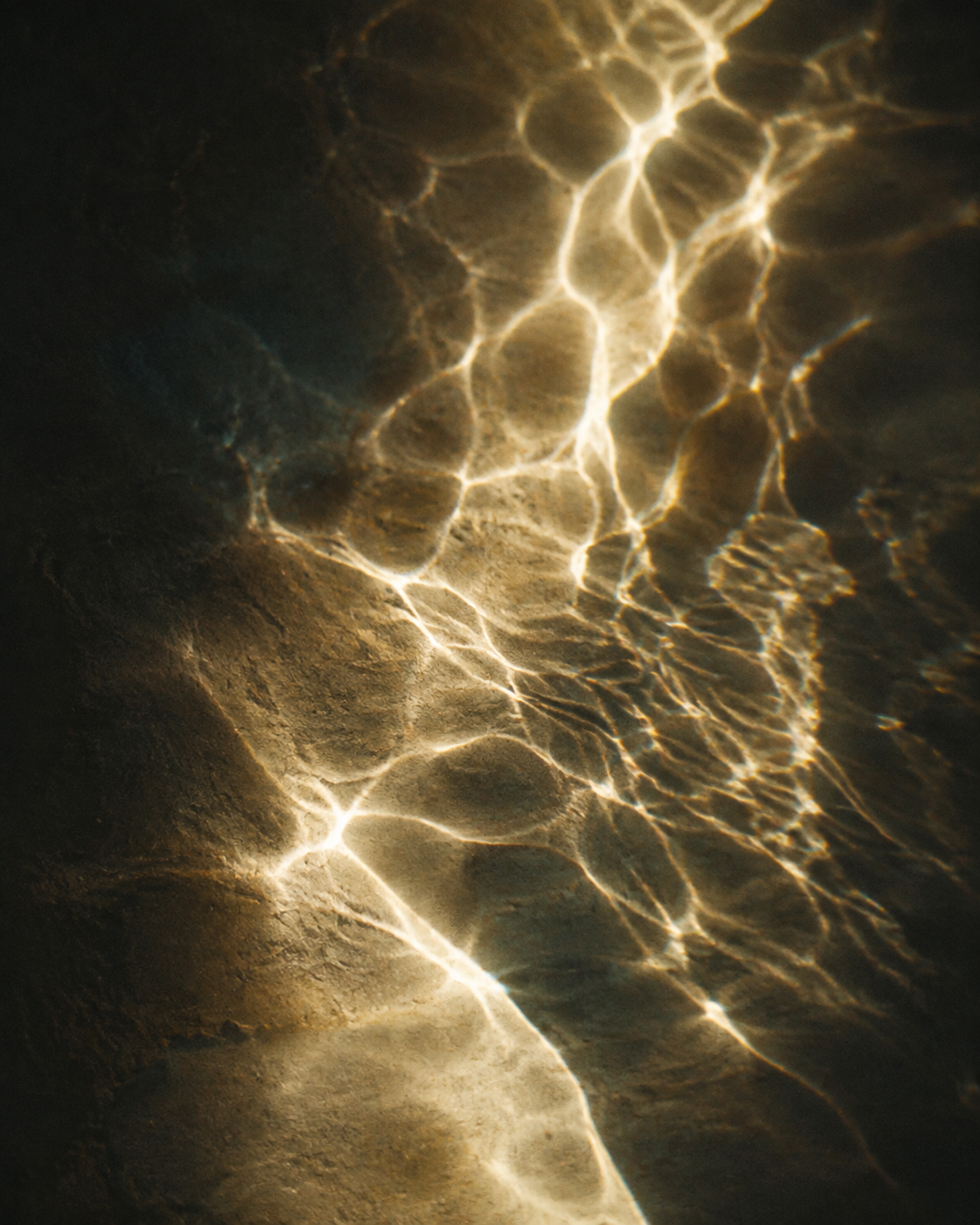 Warm refracted light moving across a dark surface
